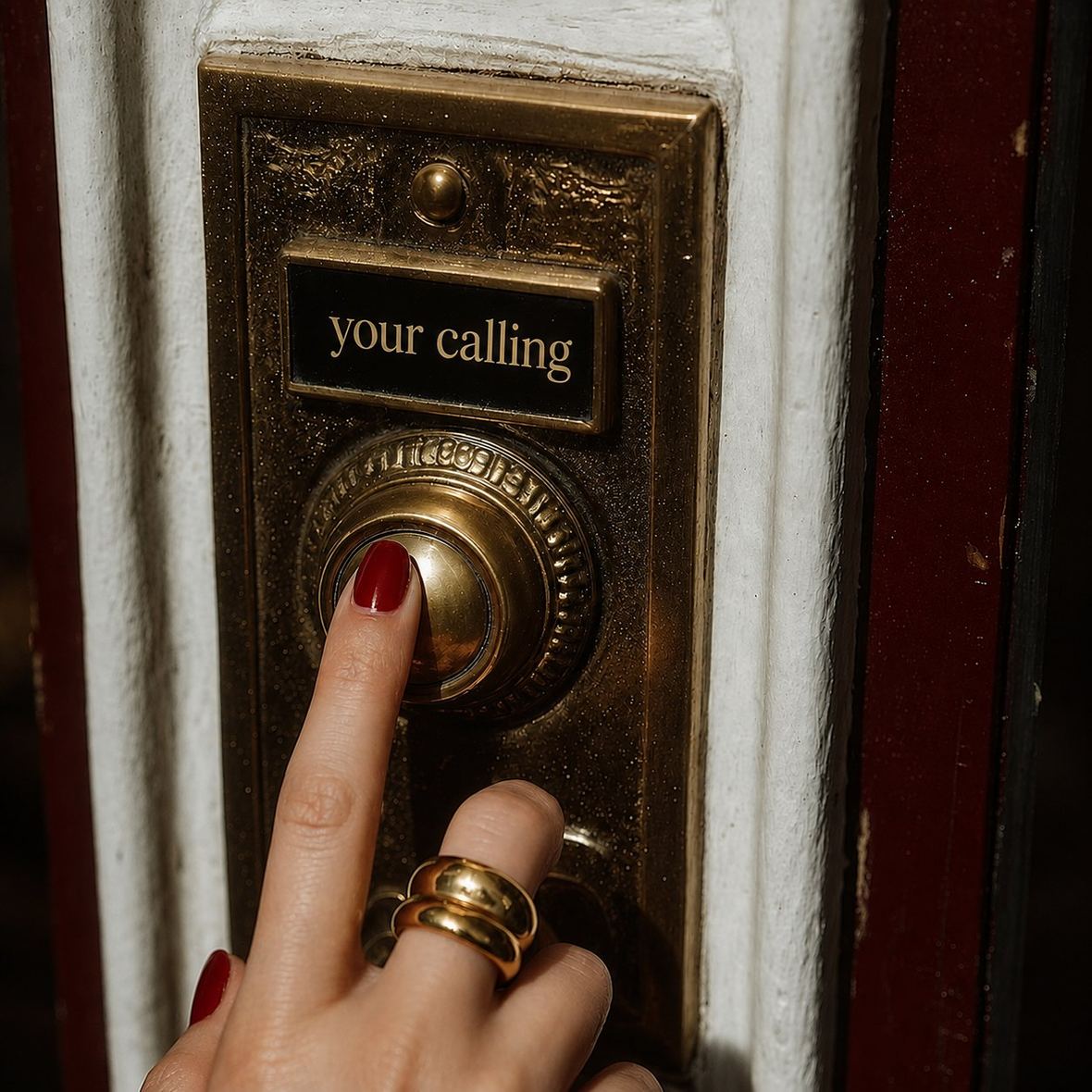 A finger pressing a brass doorbell marked your calling