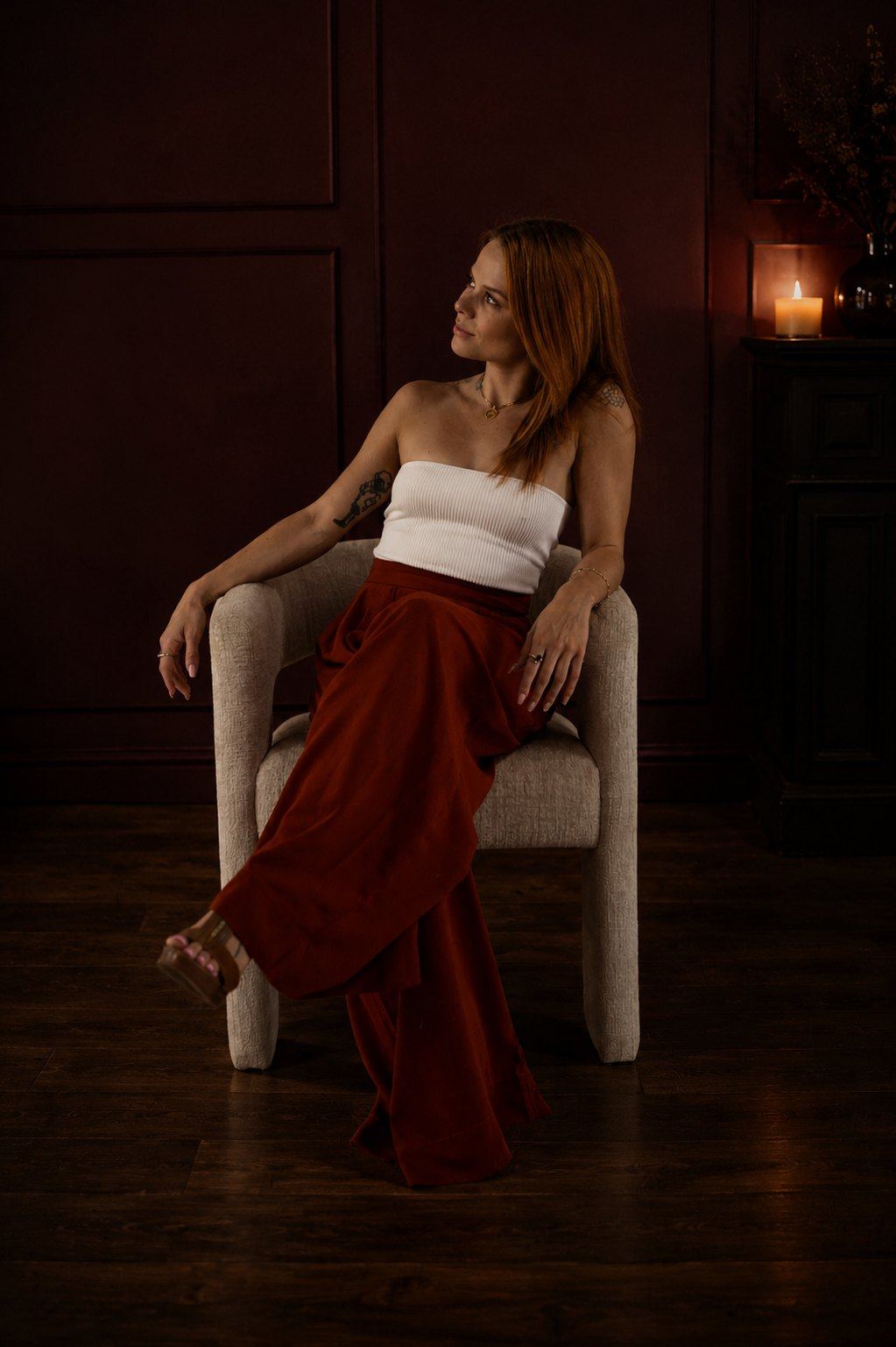 Olivia Carli seated in a deep burgundy room